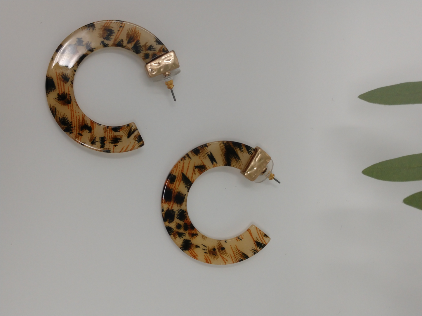 These earrings are a flat c hoop leopard print resin with a gold tone cap at the the post and measure approximately 2".