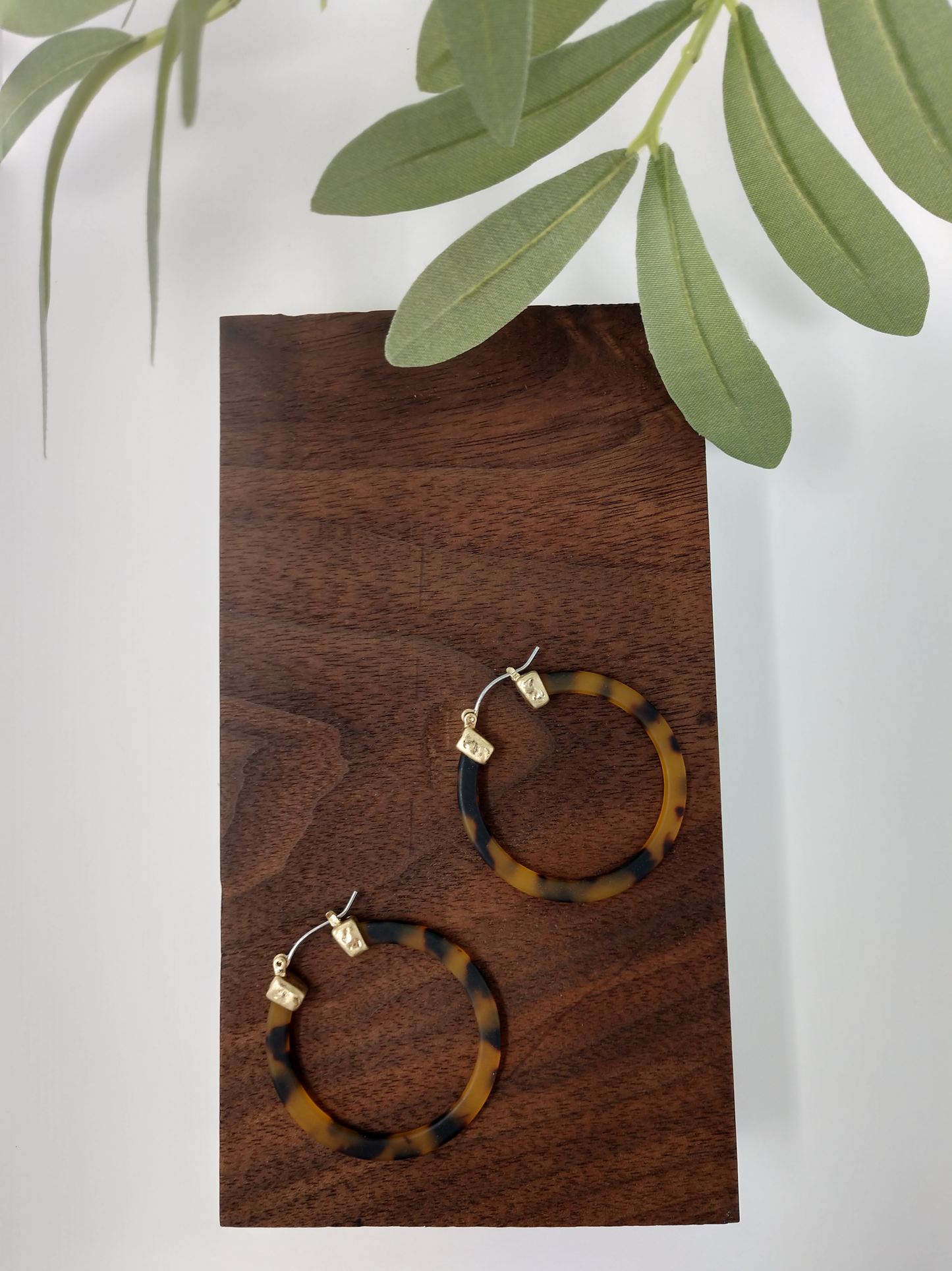 Brown tortoiseshell hoop earrings. These trendy brown tortoiseshell hoop earring is such a classy look. It would be a great compliment to your outfit and a wonderful gift idea for a friend. They are worn gold tone faux tortoiseshell hoop earrings with a snap-lock backs. They measure approximately 1.5".