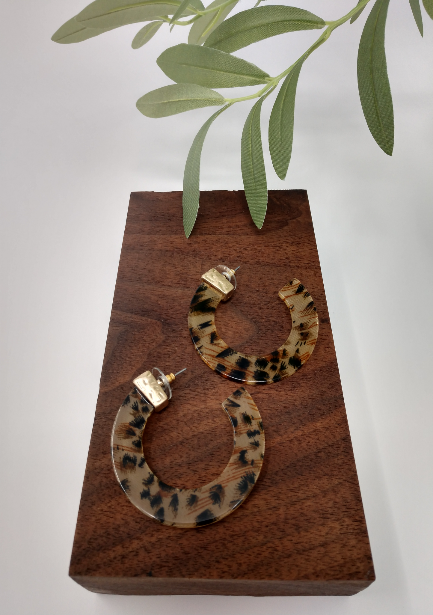 These earrings are a flat c hoop leopard print resin with a gold tone cap at the the post and measure approximately 2".