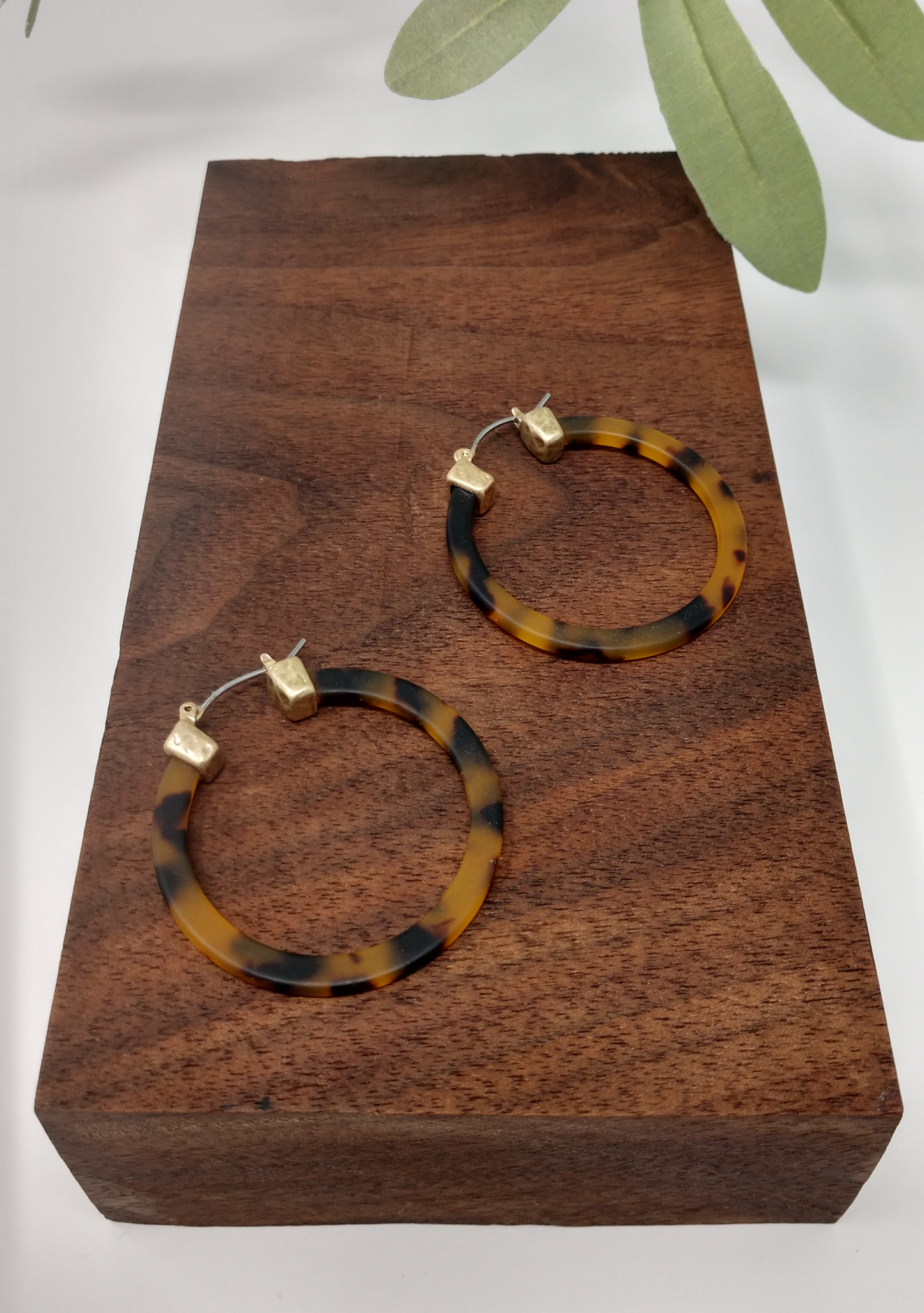 They are worn gold tone faux tortoiseshell hoop earrings with a snap-lock backs. They measure approximately 1.5".