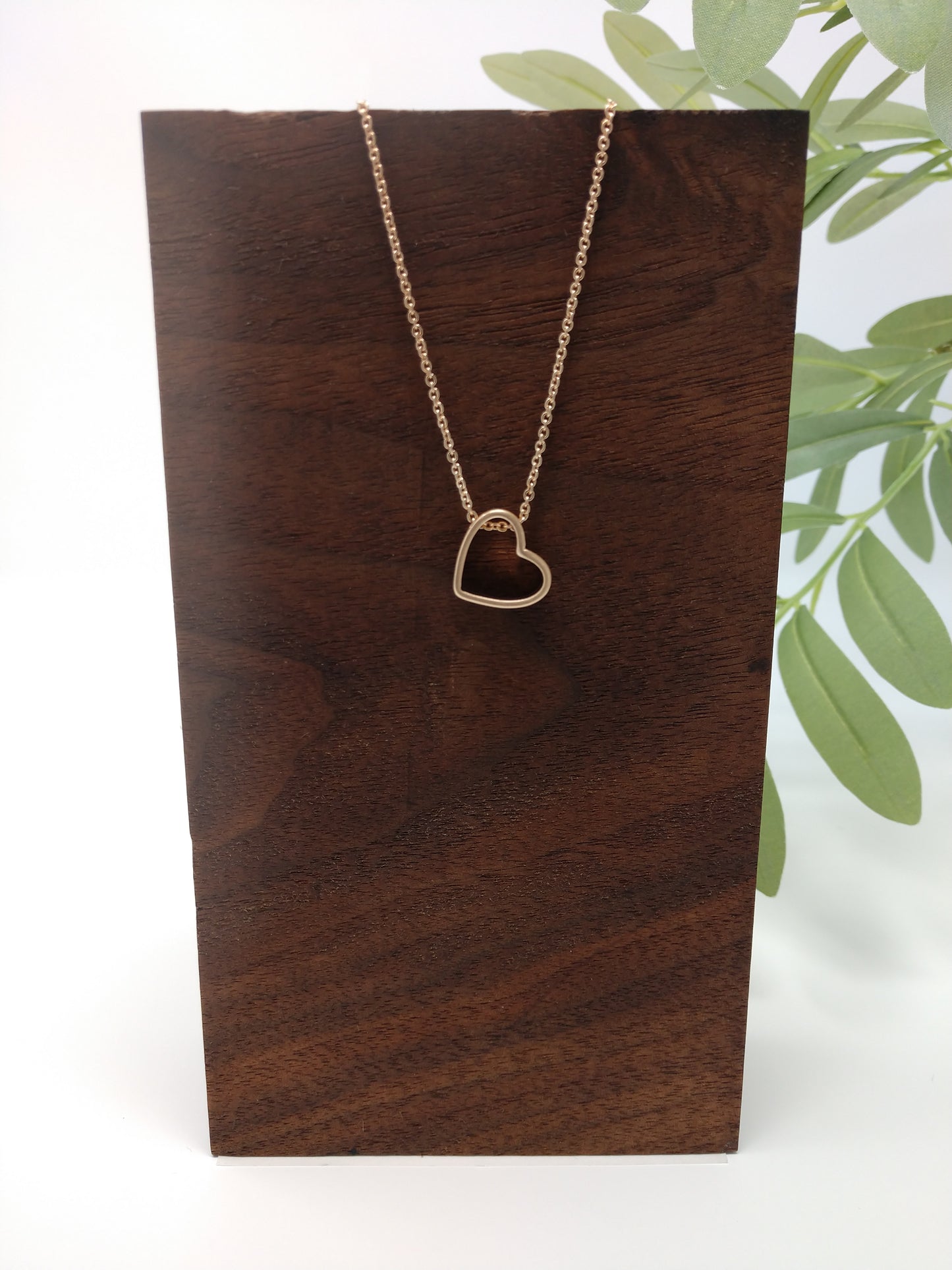 It is a 15" long worn gold tone chain with a 3" extender. The worn gold tone heart pendant measures approximately .5" and has a lobster claw closure.