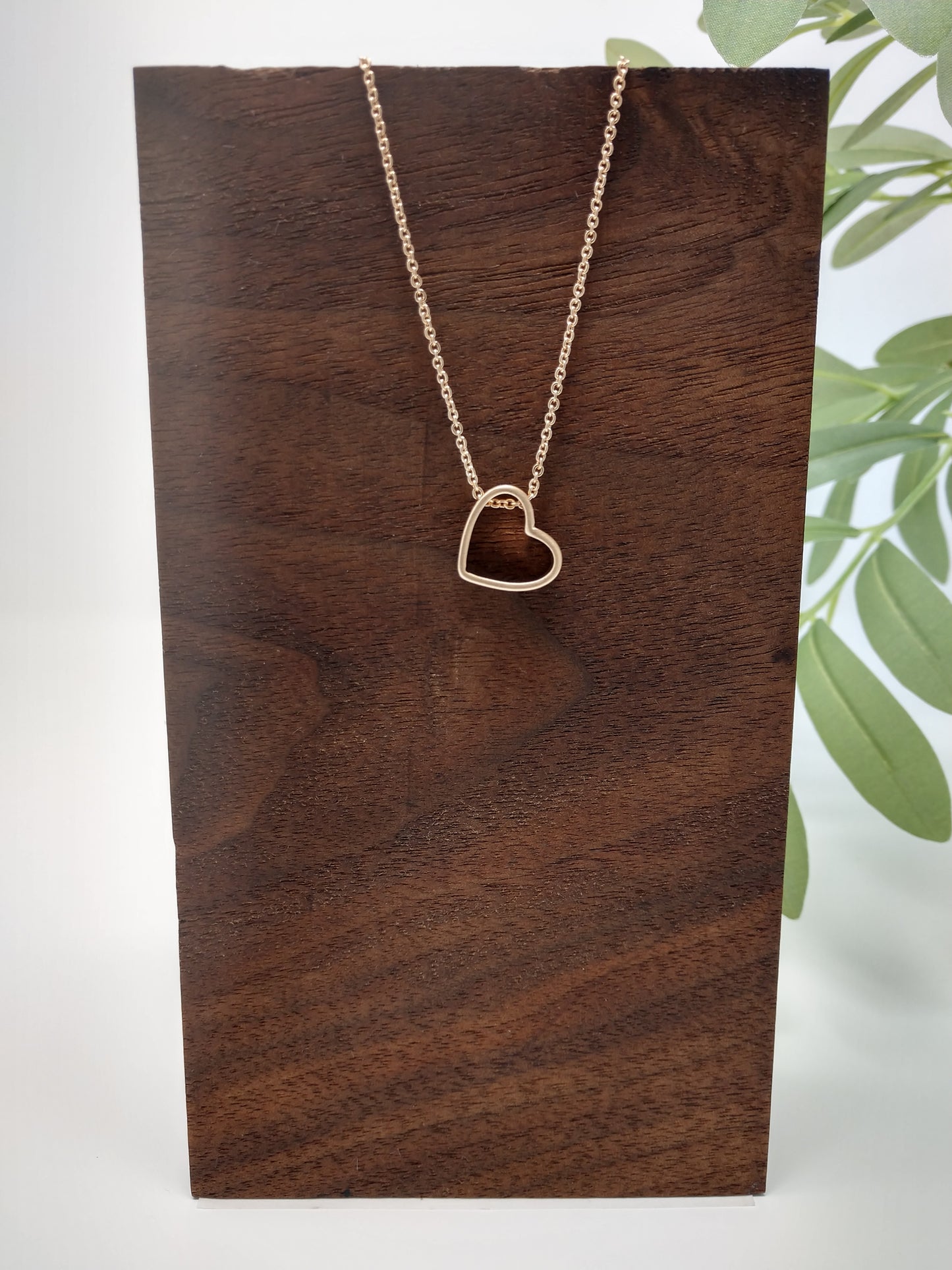 It is a 15" long worn gold tone chain with a 3" extender. The worn gold tone heart pendant measures approximately .5" and has a lobster claw closure.