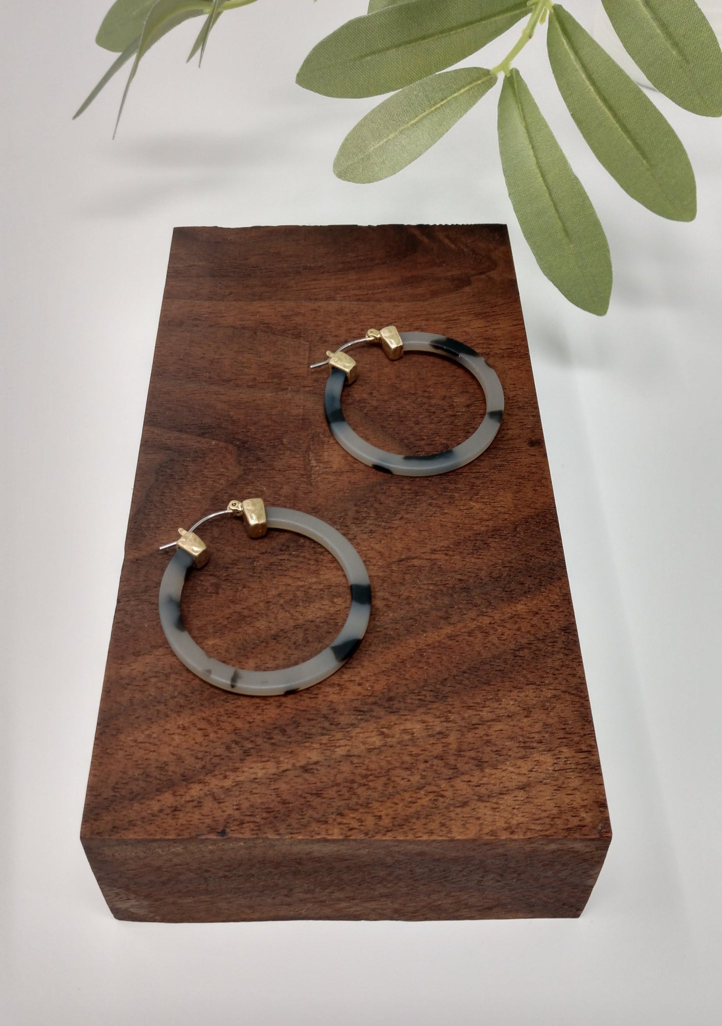 These trendy gray tortoiseshell hoop earring would be a great compliment to your outfit and a wonderful gift idea for a friend. They are worn gold tone faux tortoiseshell hoop earrings with a snap-lock backs. They measure approximately 1.5".