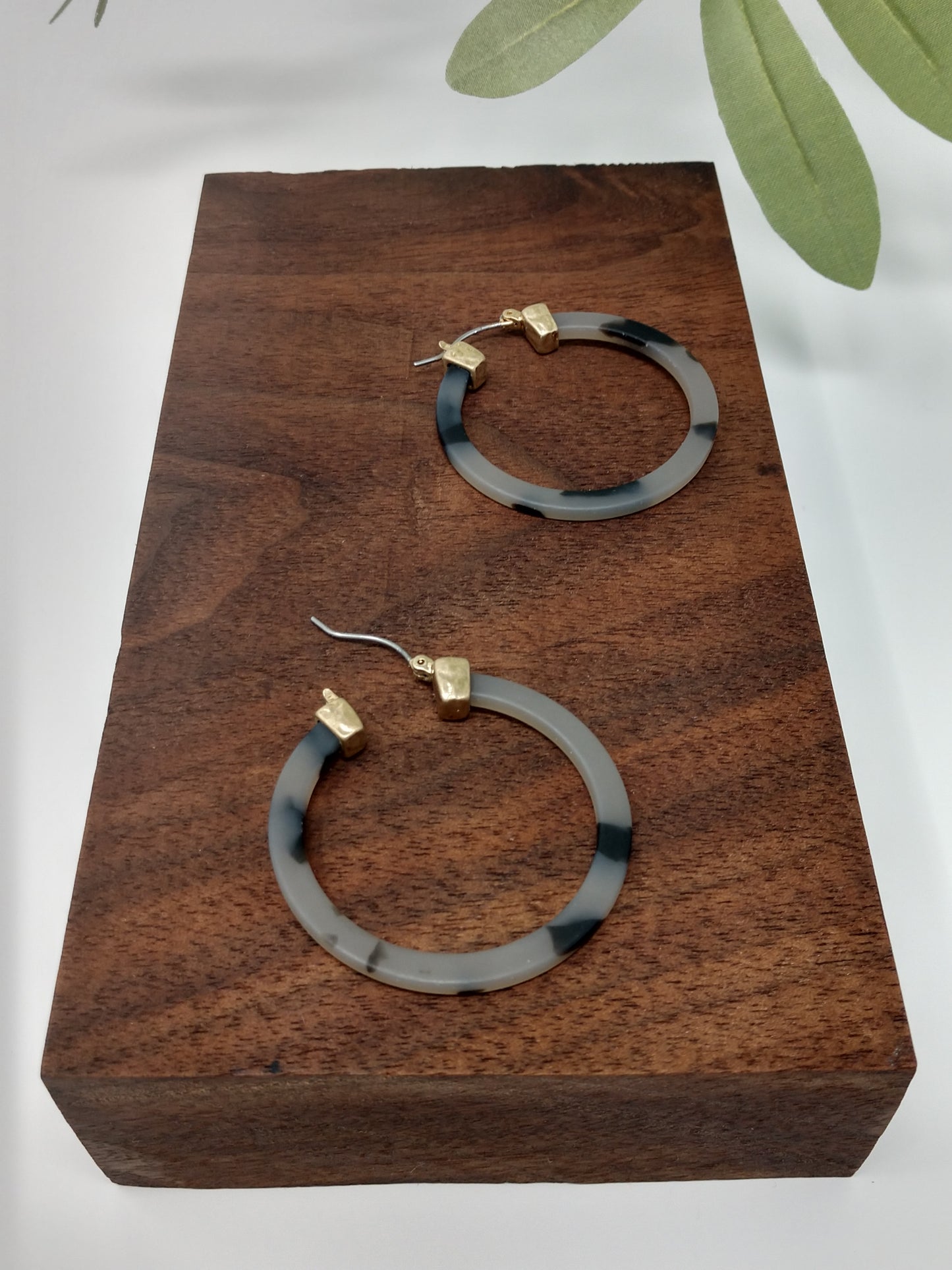 These trendy gray tortoiseshell hoop earring would be a great compliment to your outfit and a wonderful gift idea for a friend. They are worn gold tone faux tortoiseshell hoop earrings with a snap-lock backs. They measure approximately 1.5".