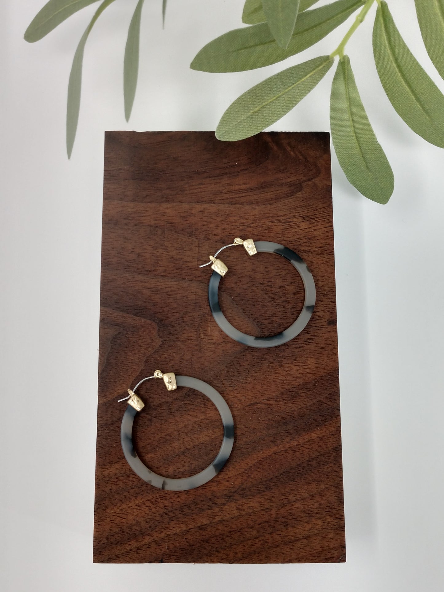 gorgeous gray tortoiseshell earring hoop. These trendy gray tortoiseshell hoop earring would be a great compliment to your outfit and a wonderful gift idea for a friend. They are worn gold tone faux tortoiseshell hoop earrings with a snap-lock backs. They measure approximately 1.5".