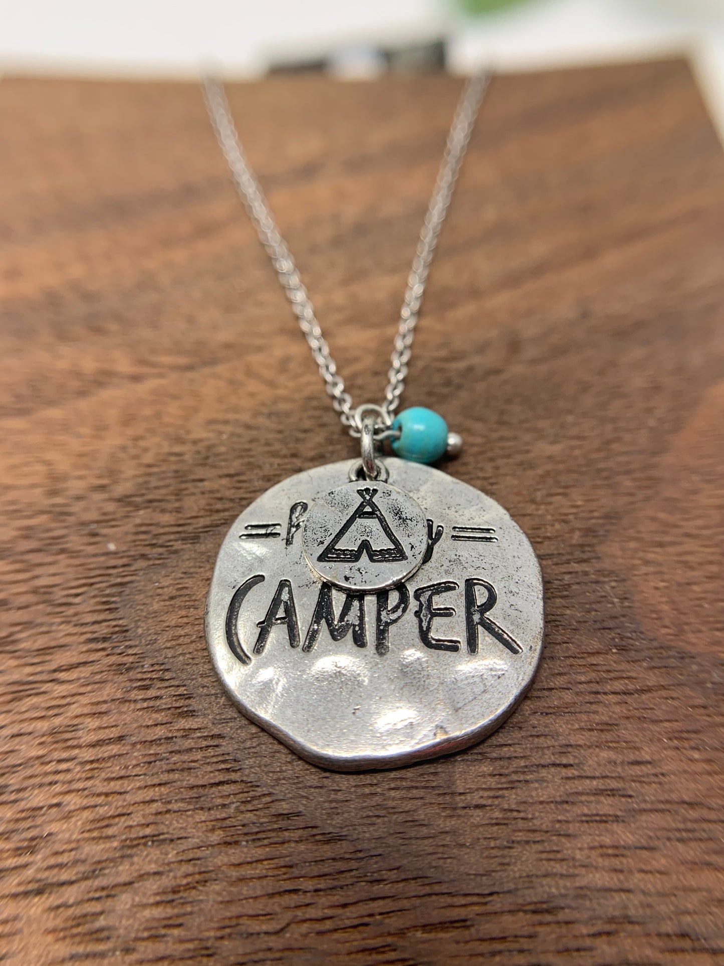 This beauty is a Silver tone chain and pendant measures approximately 9.5" with a 2" extender. The pendant says happy camper and there is a small charm with a stamped teepee image that hangs over the top of the pendant. It also comes with matching earrings!