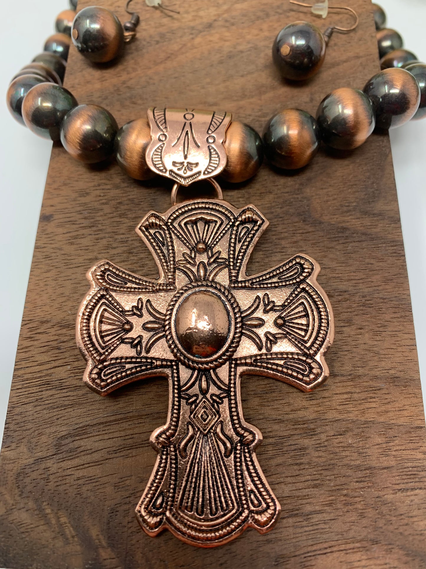 The bronze tone cross is so bright and engraved. The beads that make up the necklace are a bronze tone and black, same as the earrings. Necklace measures 12" in total length including the charm.Fashion jewelry is a great way to add affordable fun, colorful, trendy pieces to your collection.