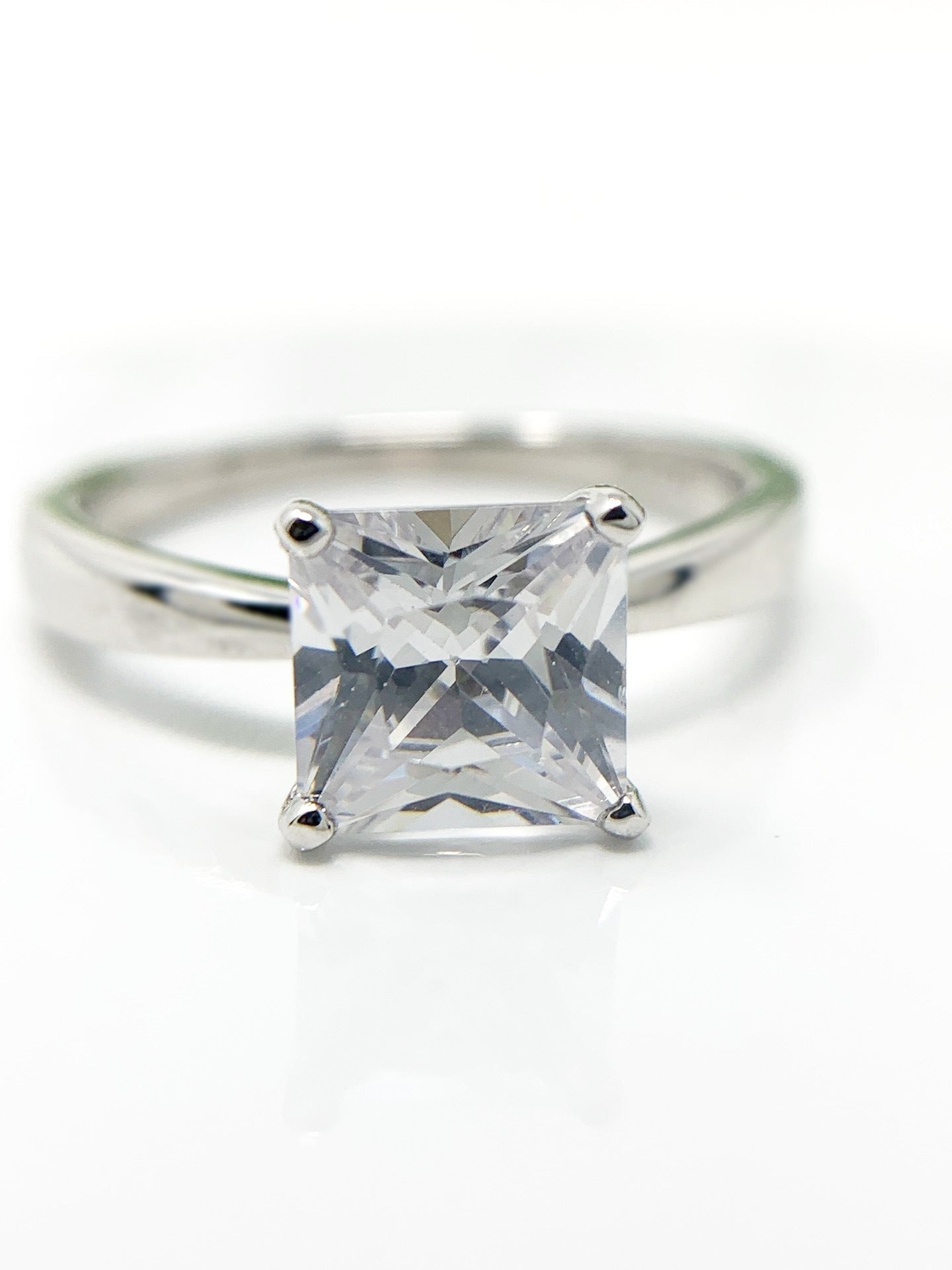 Do you love the classic look of the solitaire princess cut rings? This may be the perfect ring for you! It is gorgeous and offers that classic, timeless charm. Great gift, treat yourself! It is a 1.96ct cubic zirconia set in a high prong on a sterling silver band that is plated in rhodium to prevent tarnishing! Limited Quantity Our rings are in whole sizes only. We do carry ring sizers if you are an in between size.