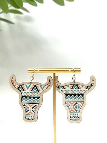 These are cattle head shaped and made of wood. They have a solid wood backing, faux leather, gold tone hardware and fishhook.