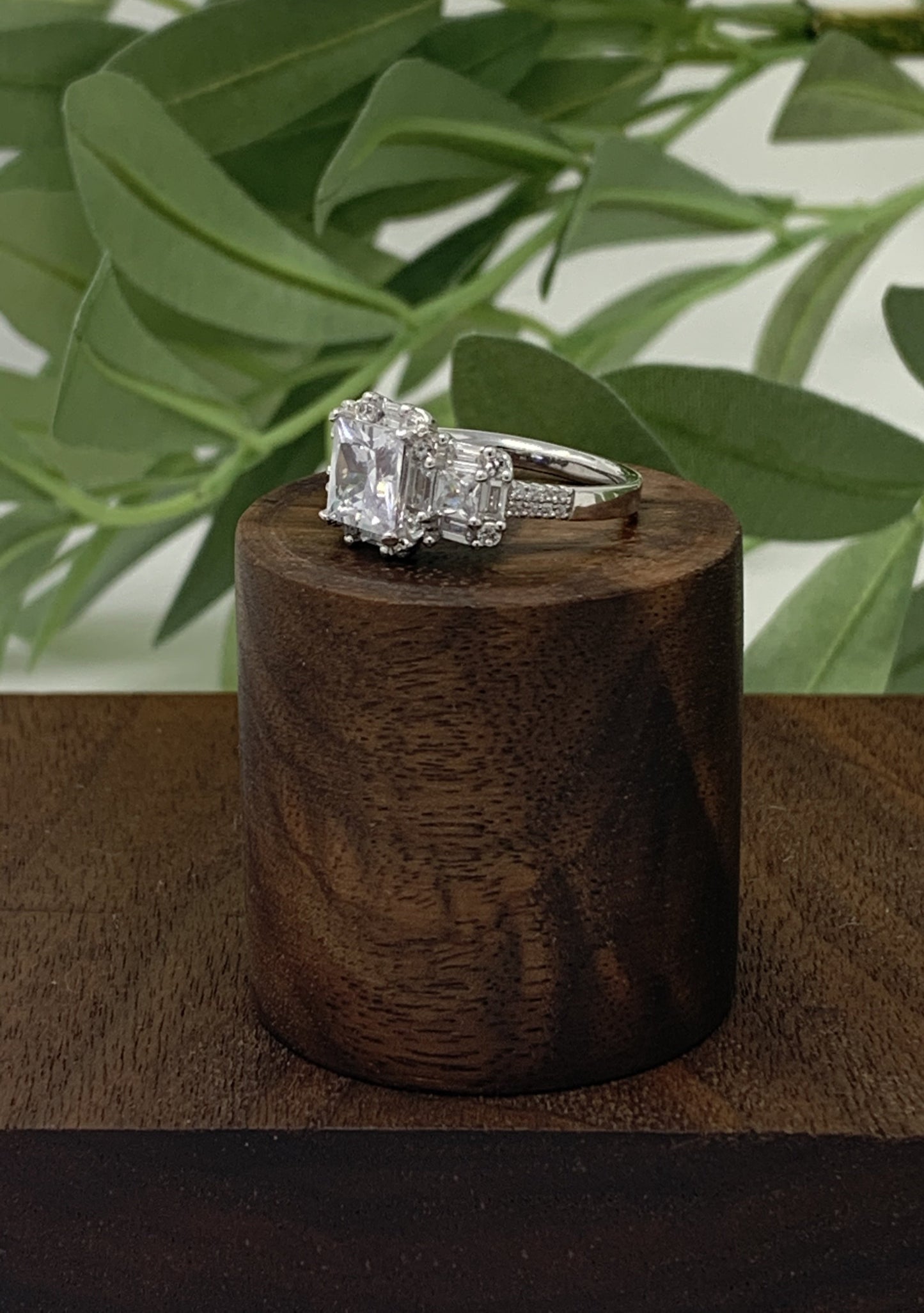 The ring has a mix of cubic zirconia (41 to be exact) in a variety of cuts. This stunner is a sterling silver ring is plated in rhodium to prevent tarnishing. The center stone is 1.28 carat princess cut cubic zirconia. The ring is finished off with 40 other stones, emerald and round cut.