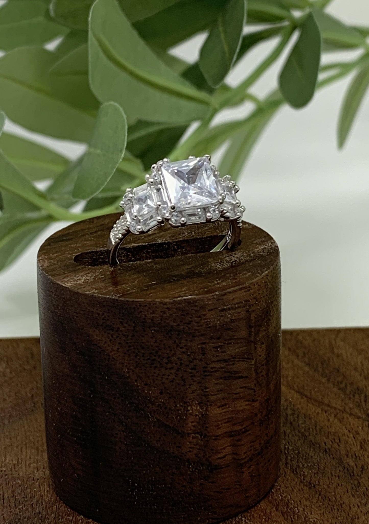 The ring has a mix of cubic zirconia (41 to be exact) in a variety of cuts. This stunner is a sterling silver ring is plated in rhodium to prevent tarnishing. The center stone is 1.28 carat princess cut cubic zirconia. The ring is finished off with 40 other stones, emerald and round cut.