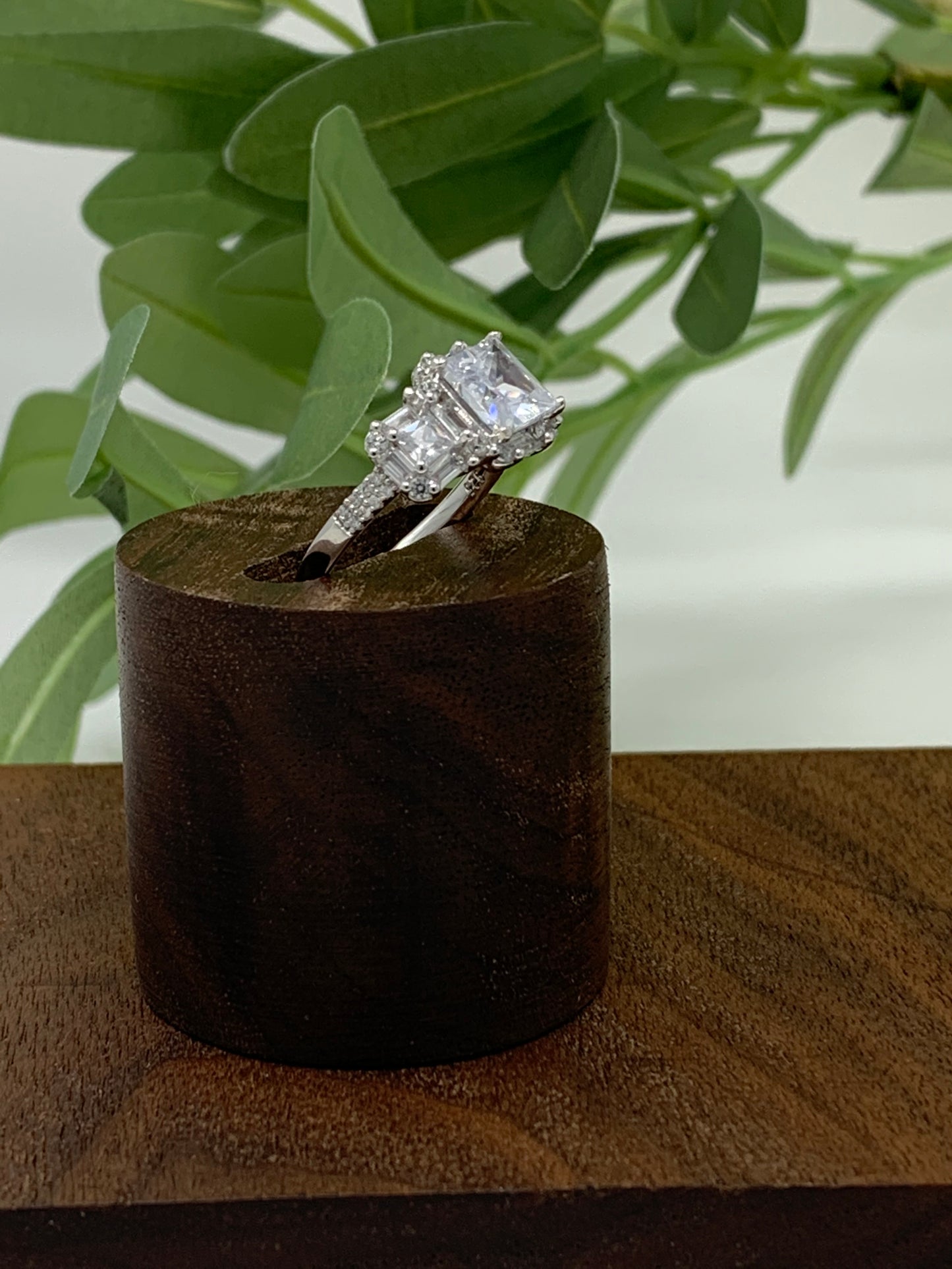 The ring has a mix of cubic zirconia (41 to be exact) in a variety of cuts. This stunner is a sterling silver ring is plated in rhodium to prevent tarnishing. The center stone is 1.28 carat princess cut cubic zirconia. The ring is finished off with 40 other stones, emerald and round cut.