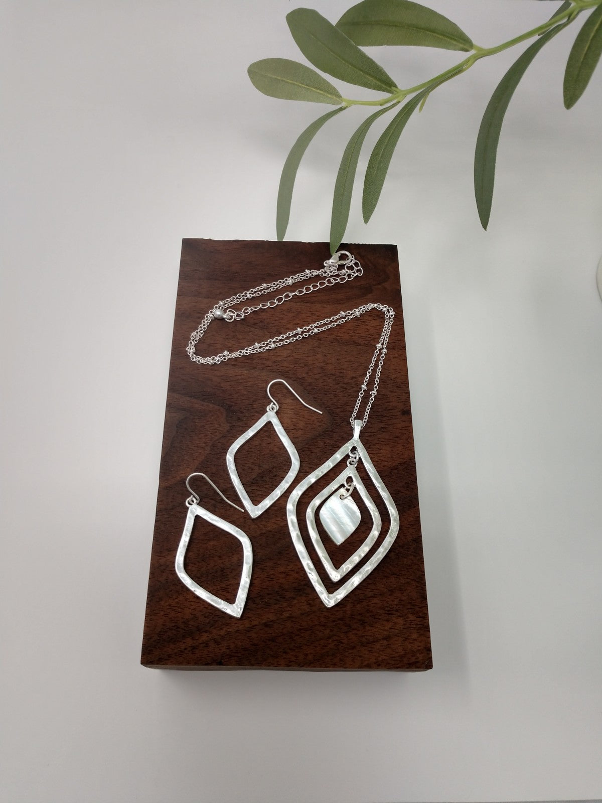This Persian style necklace is a worn silver tone Saturn chain is 18" long and comes with a 3" extender. It has two diamond shaped pendants measuring 2.5" with a faux mother of pearl in center. Lobster claw closure. The earrings are 2" fish hook style earrings with a 1.5" drop and matches the necklace perfectly.