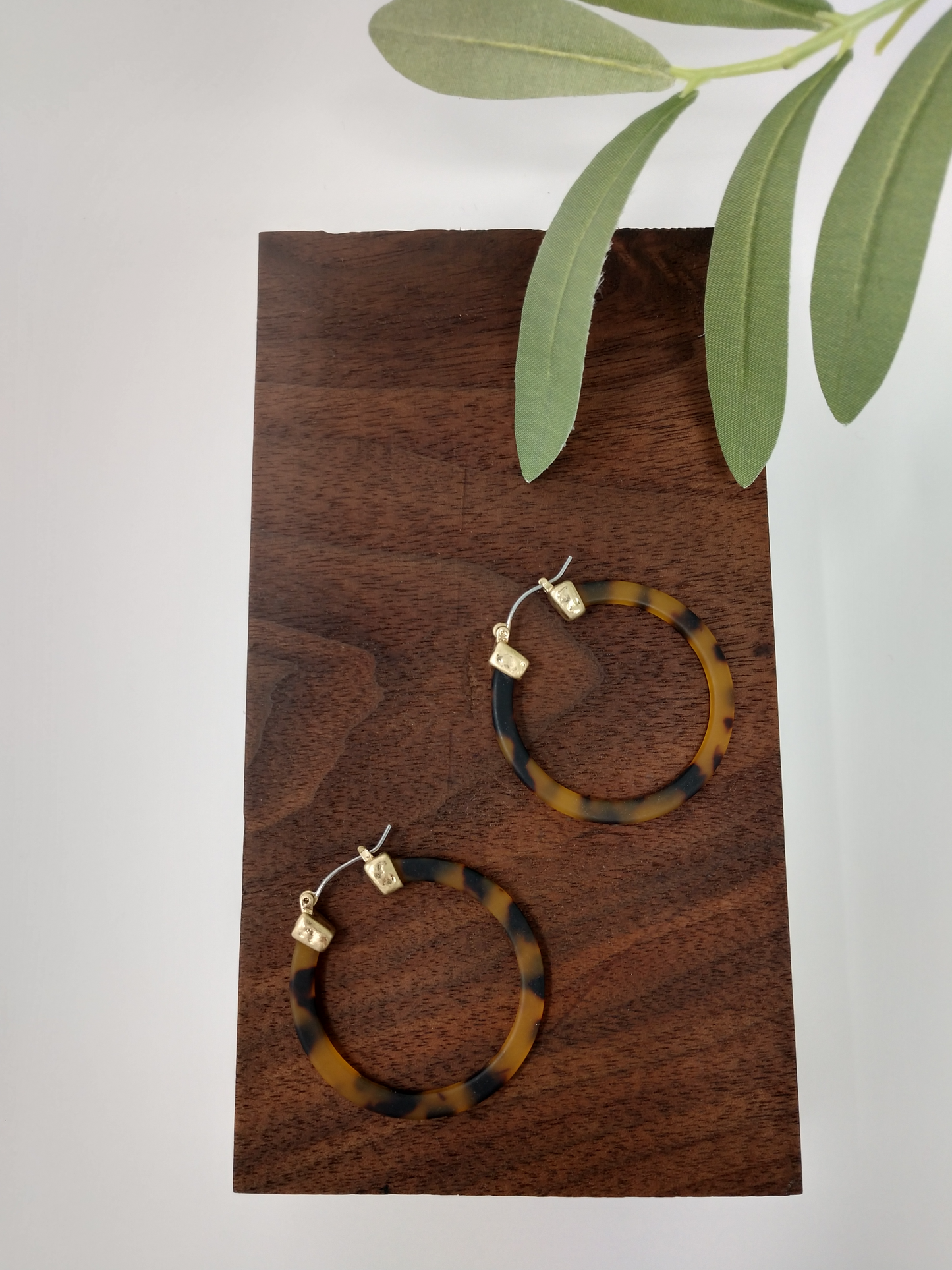 Brown tortoiseshell hoop earrings These trendy brown tortoiseshell hoop earring is such a classy look. It would be a great compliment to your outfit and a wonderful gift idea for a friend. They are worn gold tone faux tortoiseshell hoop earrings with a snap-lock backs. They measure approximately 1.5".