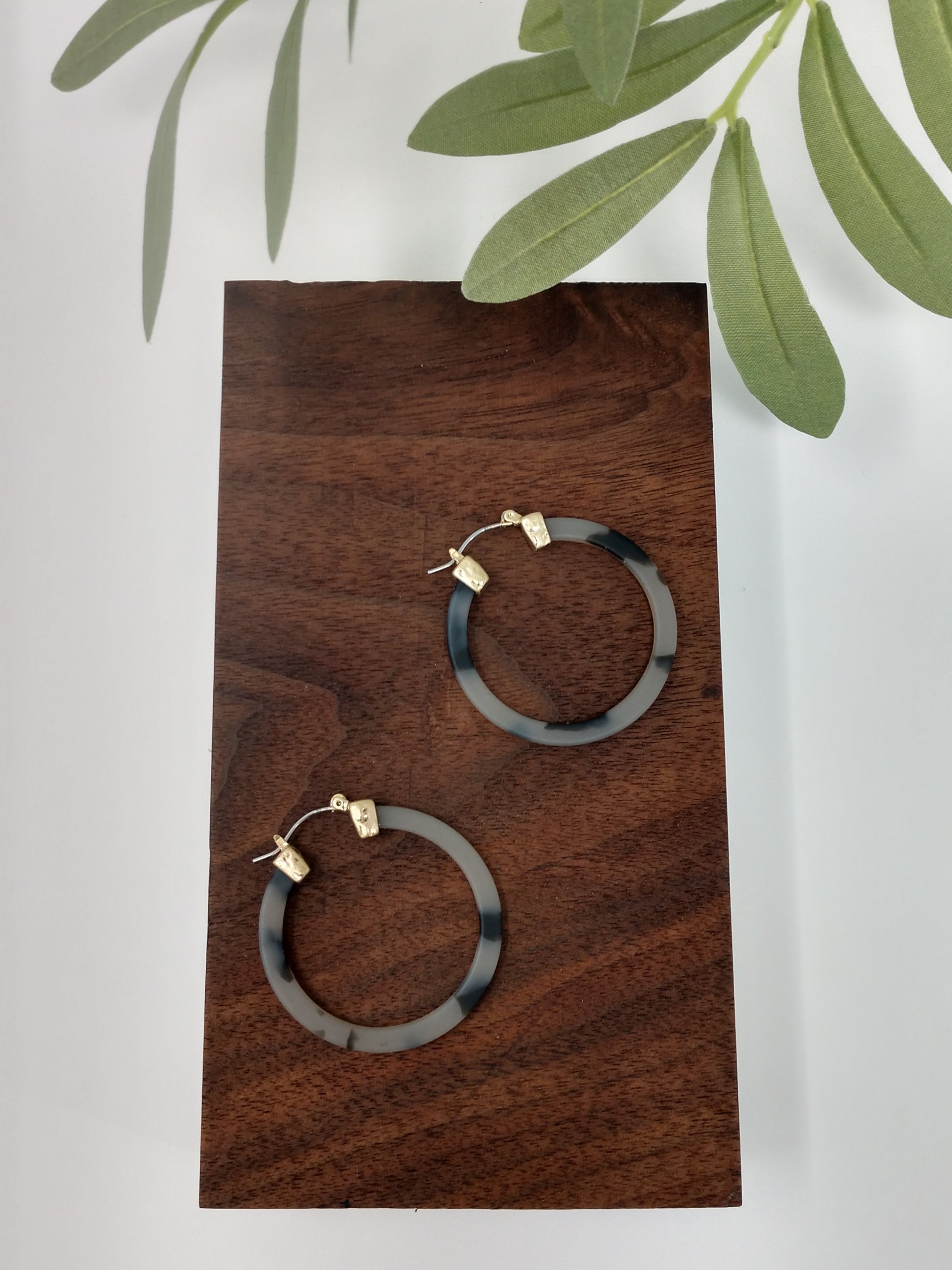 gorgeous gray tortoiseshell earring hoop.  These trendy gray tortoiseshell hoop earring would be a great compliment to your outfit and a wonderful gift idea for a friend.   They are worn gold tone faux tortoiseshell hoop earrings with a snap-lock backs. They measure approximately 1.5". 