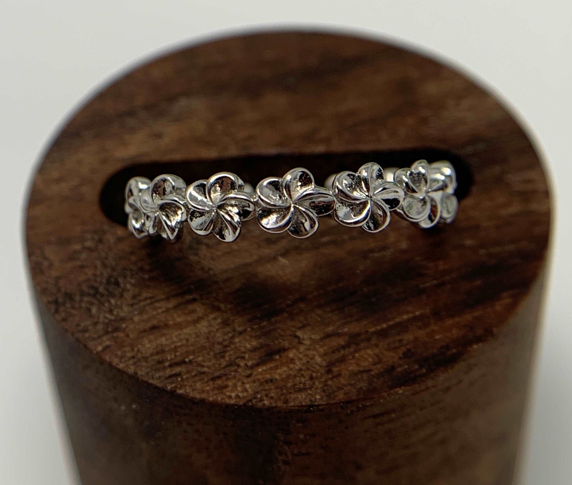 This beautiful ring is a band of Plumeria flowers. A great ring for anyone who delights in flowers or tropical flowers. The Plumeria flower represents birth, spring, love and new beginnings. So, if you are looking for a gift for the new mom, spring enthusiast, your love or a gift as a fresh start symbol well you have found just the thing.  Made from 925 Sterling Silver that is high polished and rhodium plated to prevent tarnishing.