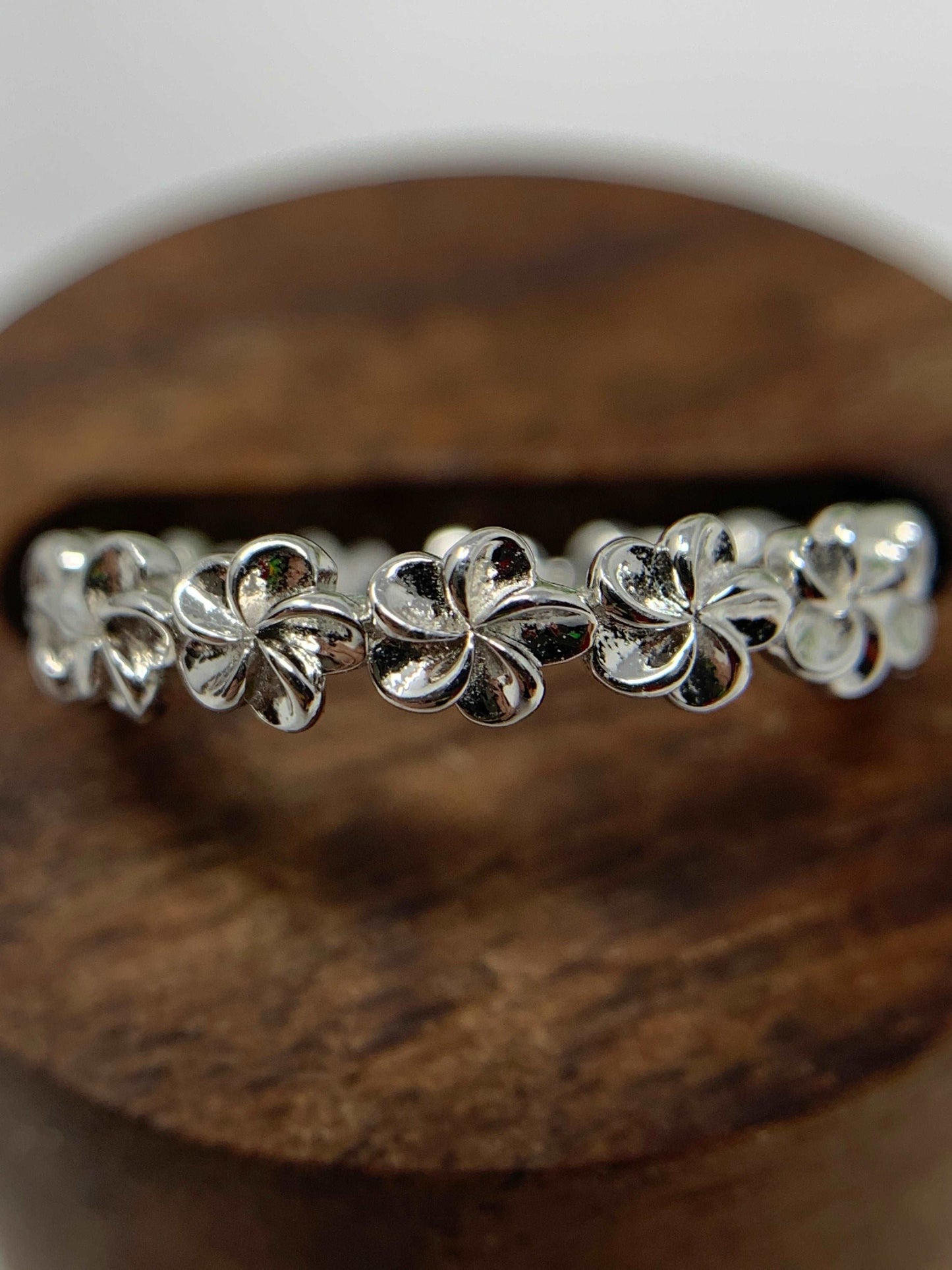 This beautiful ring is a band of Plumeria flowers. A great ring for anyone who delights in flowers or tropical flowers. Made from 925 Sterling Silver that is high polished and rhodium plated to prevent tarnishing.