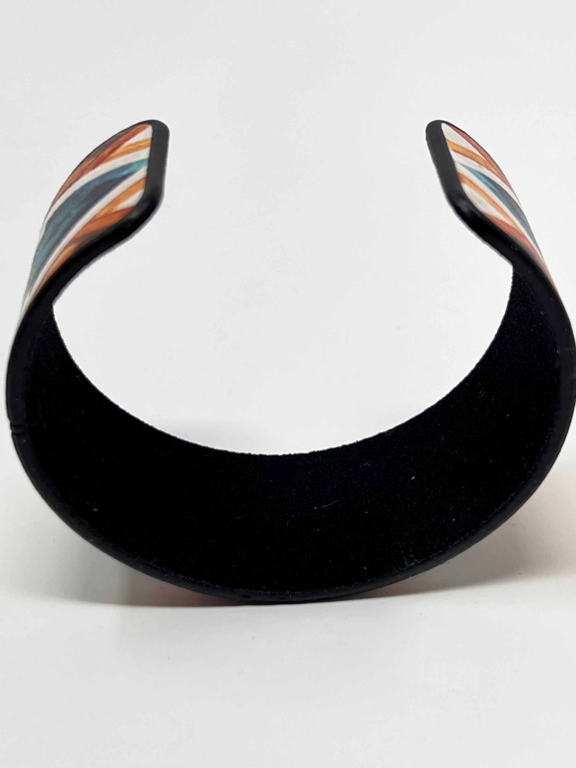 The golden lake cuff bracelet is burnished silver tone with a faux leather construction with a soft felt interior. There is no closure, it is a cuff bracelet. 1.25" wide bracelet with a 7.25" inside circumference including gap.