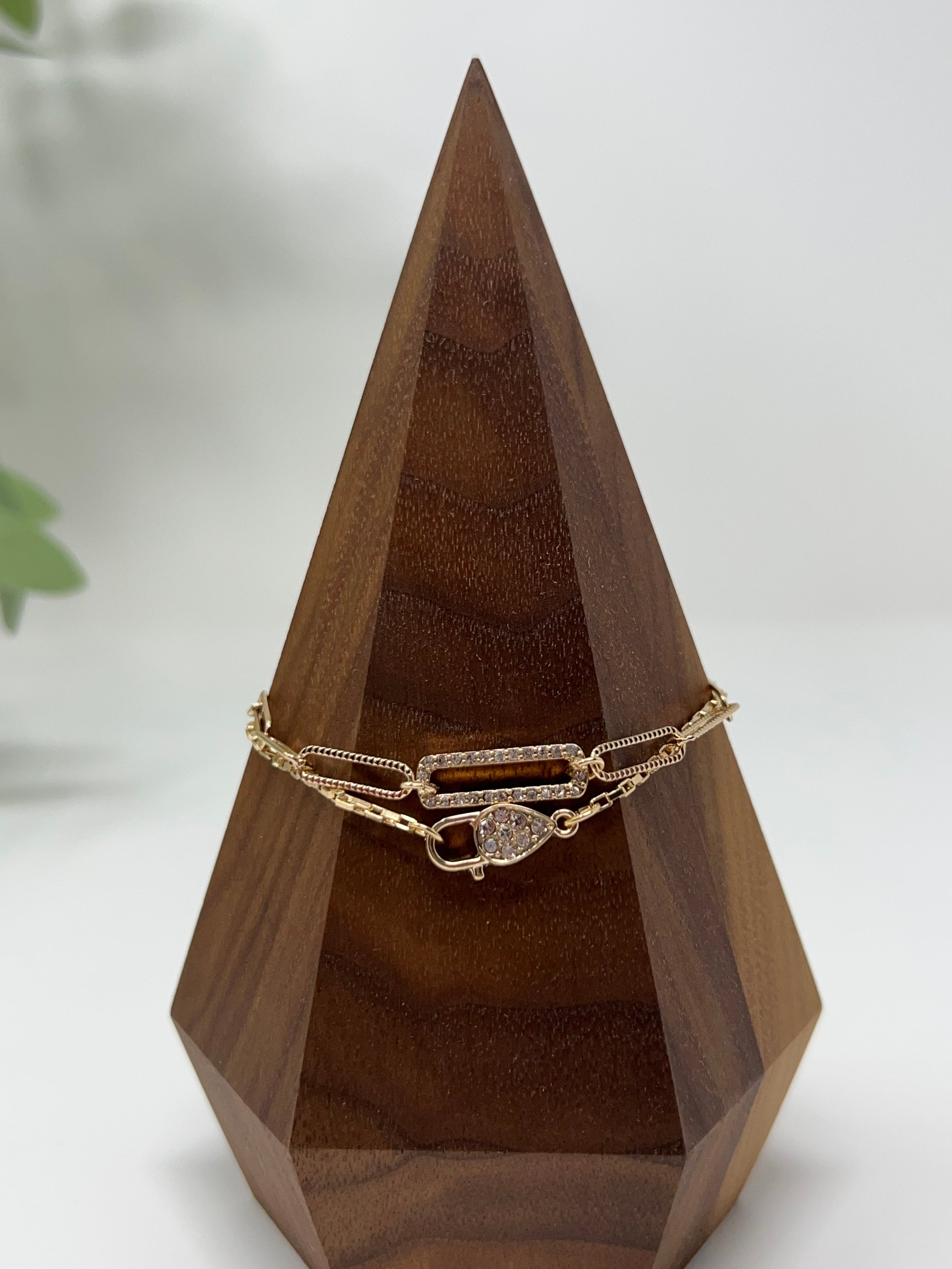 This bracelet is gold tone and is two bracelets. One has a crystal lock and box chain and the other is oval (paperclip) links. They are 7" long with a 2" extender. Lobster claw closure. The lock & oval links measure approximately .75". 