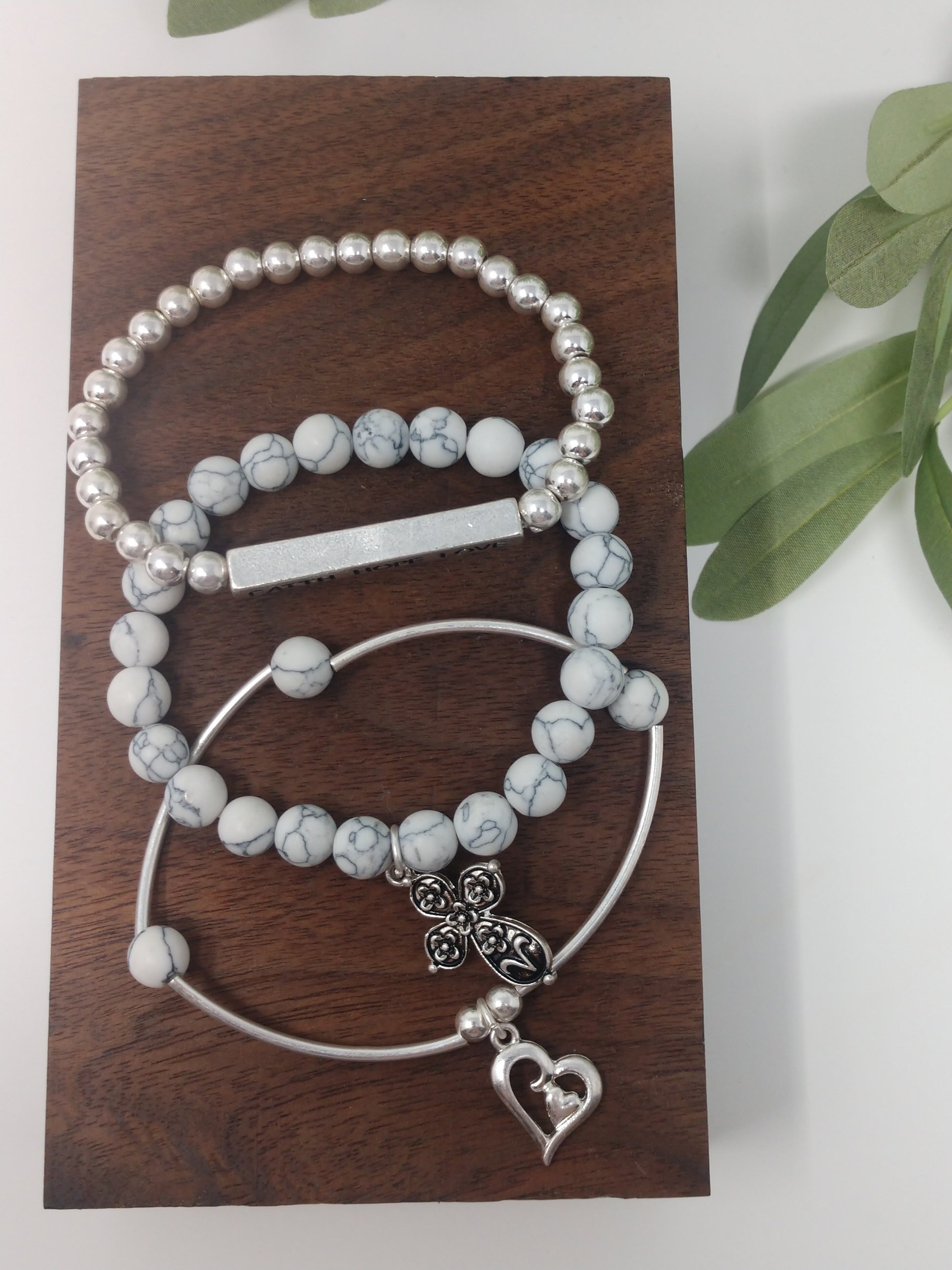 The faux stones, worn silver tone, and metal beads go together so beautifully. There is also a 1.5" engraved metal cube. A .75" heart charm and a 1" floral cross charm. Each bracelet is a comfort stretch so there is no closure. That allows for easy on and off. 2.25" diameter.  