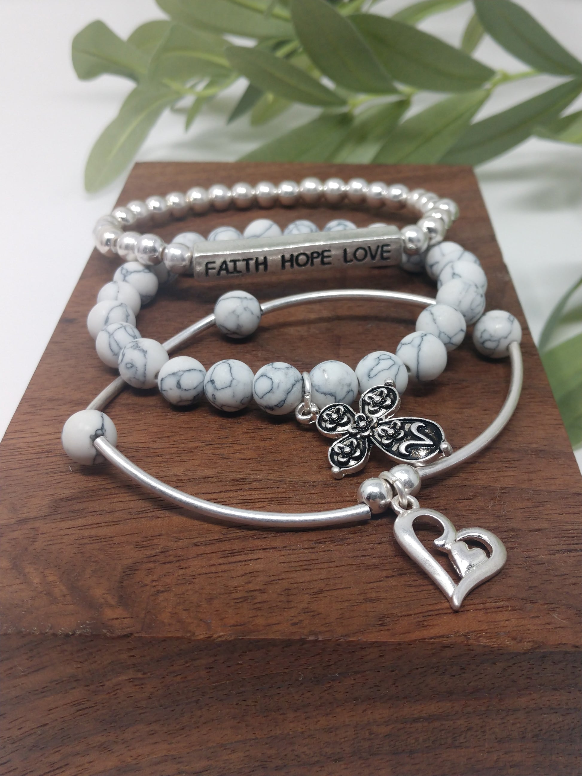 The faux stones, worn silver tone, and metal beads go together so beautifully. There is also a 1.5" engraved metal cube. A .75" heart charm and a 1" floral cross charm. Each bracelet is a comfort stretch so there is no closure. That allows for easy on and off. 2.25" diameter.  