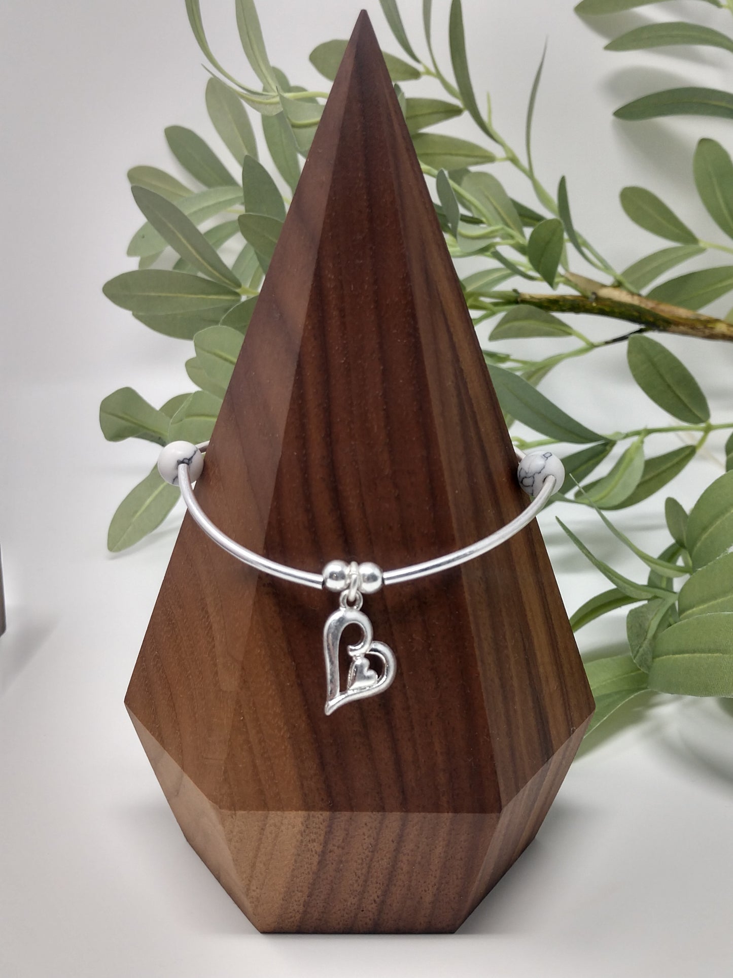 The faux stones, worn silver tone, and metal beads go together so beautifully. There is also a 1.5" engraved metal cube. A .75" heart charm and a 1" floral cross charm. Each bracelet is a comfort stretch so there is no closure. That allows for easy on and off. 2.25" diameter.  