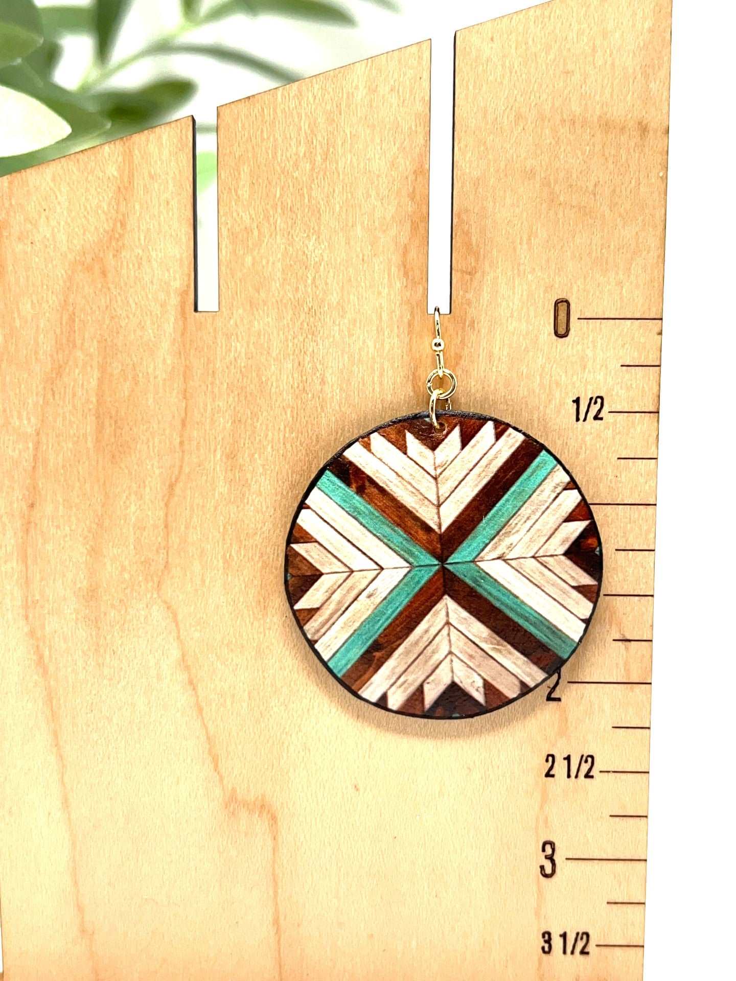 They are a soft faux leather in a teal, brown and cream color. Gold tone hardware connects to a gold tone fishhook.