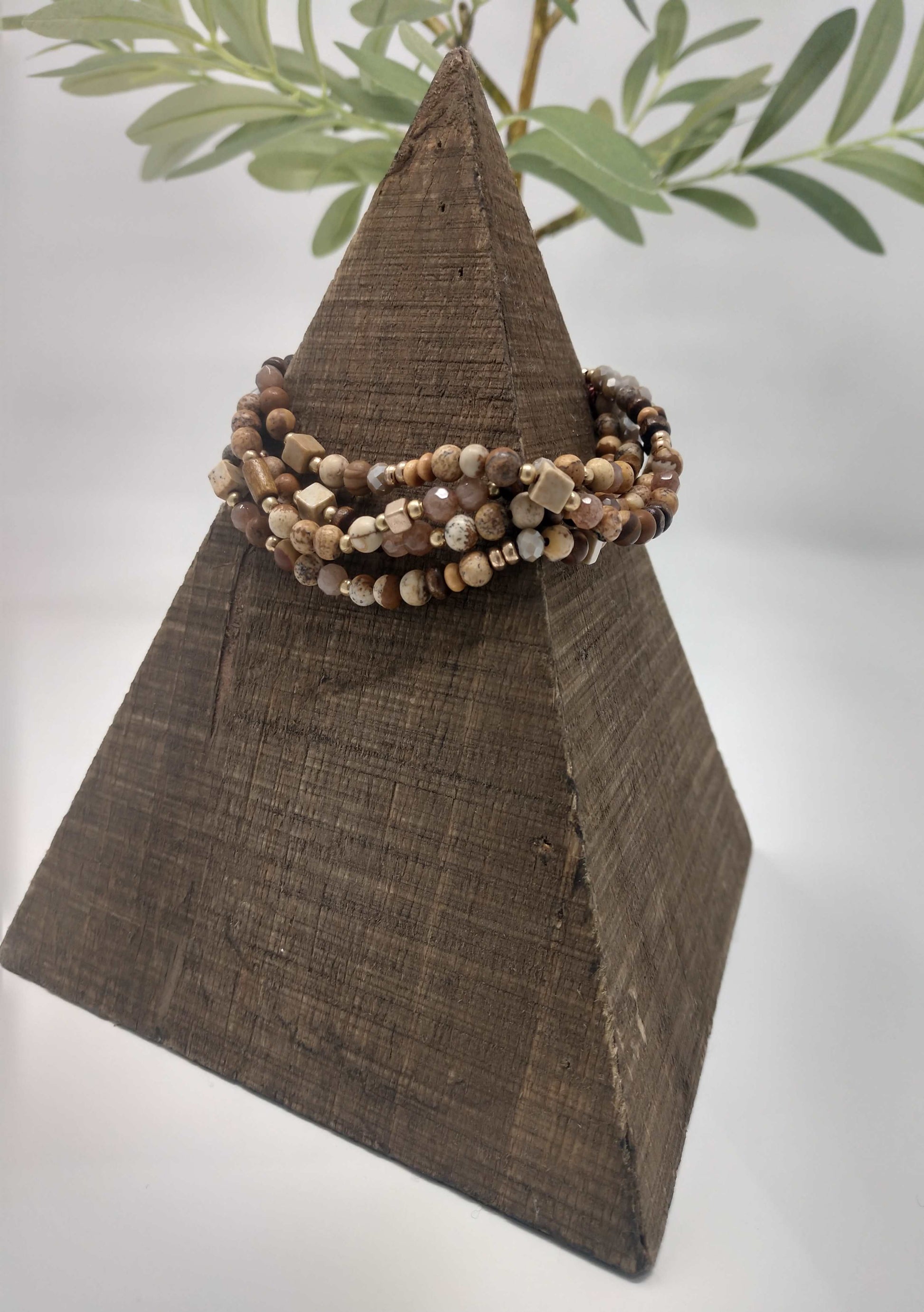 Made of four strands of semi precious stone picture jasper, worn gold tone beads, faceted, smooth and wood beads. Paired with round, cube, tubular and spacer beads for a beautiful design. It is a pull tied adjustable cord bracelet so their is no clasp closure. 