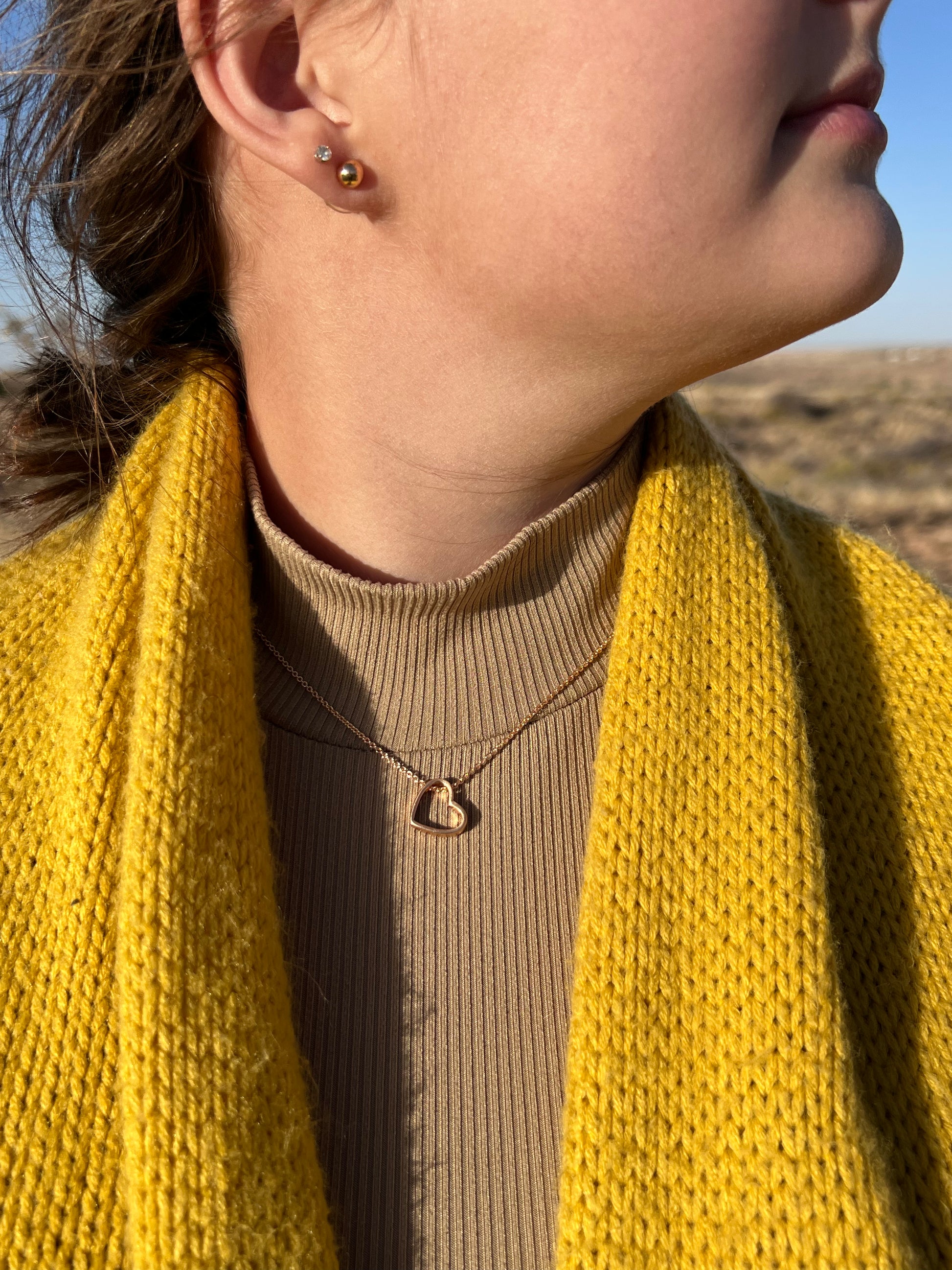 It is a 15" long worn gold tone chain with a 3" extender. The worn gold tone heart pendant measures approximately .5" and has a lobster claw closure. Plus, it comes with cute .25" post style earrings to match. 