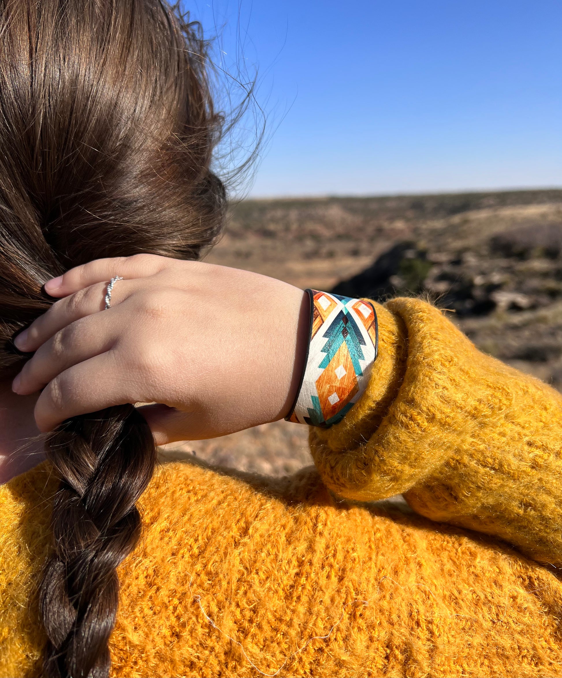 The golden lake cuff bracelet is burnished silver tone with a faux leather construction with a soft felt interior. There is no closure, it is a cuff bracelet. 1.25" wide bracelet with a 7.25" inside circumference including gap.